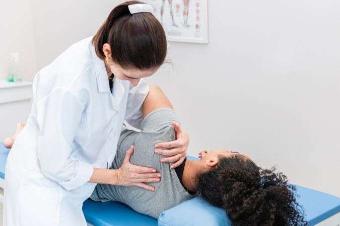 chiropractor helping patient with a frozen shoulder