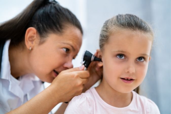 Chiropractor Assessing Child for Ear Infections
